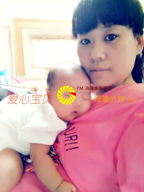 宝宝在爱心宝贝家政公司育婴师孙贺玲的身上睡着了